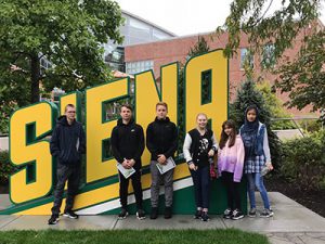 picture of six students standing in front of Siena College sign