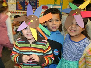 picture of three kindergarten students wearing turkey headbands