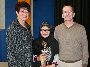 picture of spelling bee champion holding trophy.