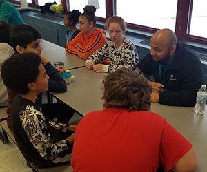 picture of small group of students and Fidelis Care facilitator eating lunch together