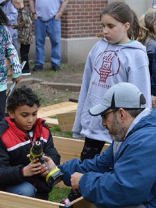 picture of parent volunteer showing student how to work a drill