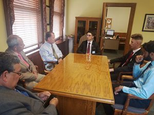 picture of students in mayor's office seated at table talking with the mayor and council members