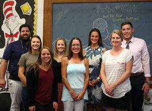 picture of new teachers and staff members standing in front of chalkboard in elementary school library