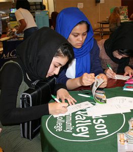 picture of students looking through admission materials at College Caravan
