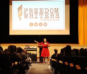 picture of author with microphone in hand addressing the audience