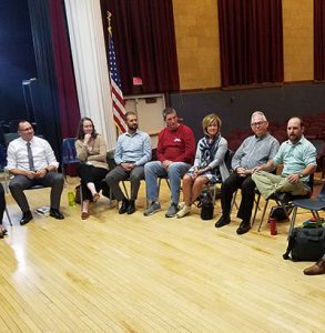 picture of educators seated in circle in auditorium engaged in conversation