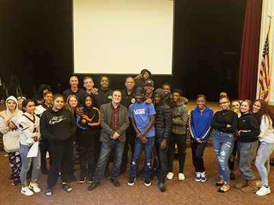 picture of students in the auditorium with Albany Patroons coach, player and general manager