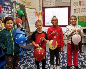 picture of four students holding up their finished parade balloon characters