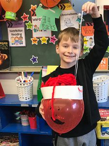 picture of student holding red balloon