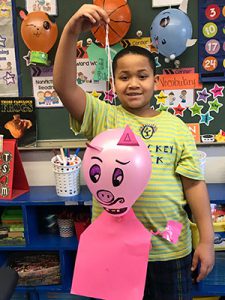 picture of student holding pink pig balloon