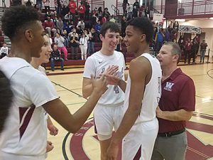 picture of basketball players on court celebrating 1000 points