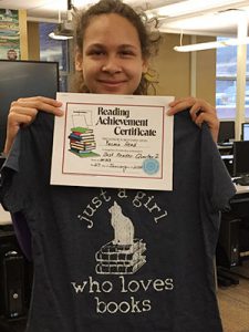picture of top reader holding certificate and special t-shirt
