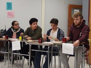 picture of four varsity Masterminds team members seated at desks participating in competition