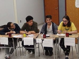 picture of four varsity Masterminds team members seated at desks participating in competition