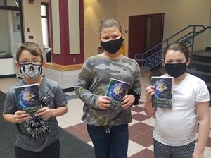 picture of three third grade students receiving dictionaries