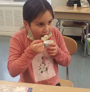 student enjoys a taste of the ice cream made as part of learning activity