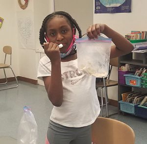 student enjoys a taste of the ice cream made as part of learning activity