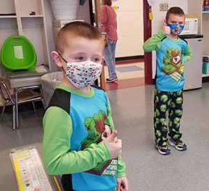 picture of two students wearing the same pajamas with thumbs up sign