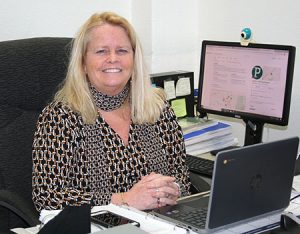 picture of Janelle Yanni, Director of Pupil Personnel Services and Programs seated at her desk, smiling