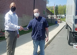 picture of high school principal shaking hands with alumna who donated the mattresses.