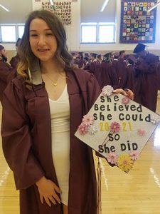 picture of graduate holding decorated cap and smiling for the camera