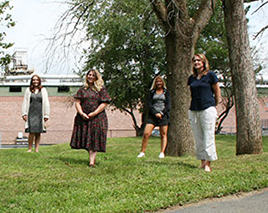 picture of four (4) new teachers and staff standing outside WES playground area