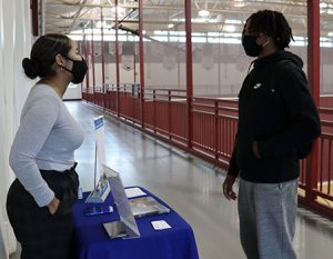 picture of college admissions counselor engaged in conversation with high school student.