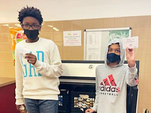 picture of two students standing in lunch line holding up tickets