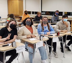 Picture of four students seated at desks practicing skills for Masterminds competition