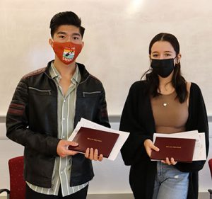 picture of two high school students holding their diplomas