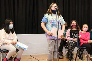 picture of student standing at microphone at spelling bee