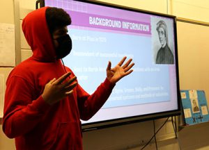 picture of student standing in front of whiteboard presenting math project