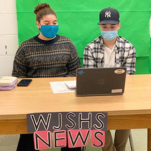 picture of Vliet News announcers seated at desk with laptop open