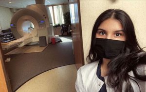 picture of student standing in doorway with MRI machine in background