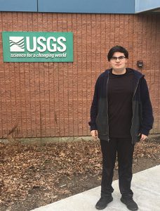picture of student standing outside USGS brick building