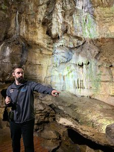 picture of tour guide pointing to rock formation in Howe Caverns