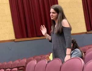 picture of student with hand raised pledging the oath to uphold the requirements of membership in National Honor Society