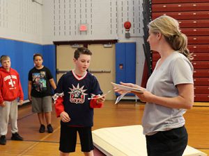 coach hands an awards certificate to a student