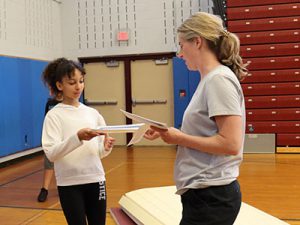 coach hands an awards certificate to a student