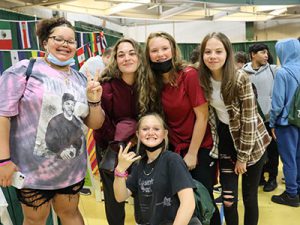 Five students stand together smiling at camera with Career Jam activities in the background.