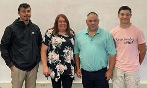 New board of education member Brian White stands beside his wife and two children after taking the oath of office at the organizational meeting in July.