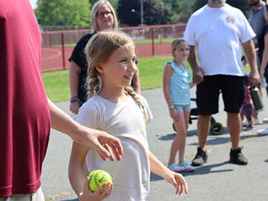 Young student with softball in hand waiting to throw at dunk tank target.