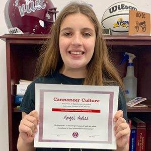 grade 7 student smiling at camera holding Cannoneer Culture certificate for Being Positive