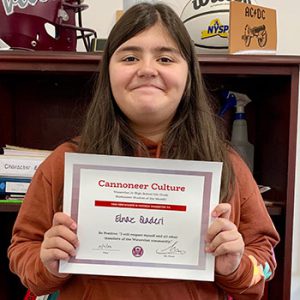 grade 6 student smiling at camera holding Cannoneer Culture certificate for Being Positive