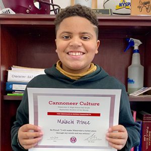 grade 6 student smiling at camera holding Cannoneer Culture certificate for Being Proud