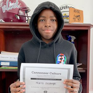 grade 8 student smiling at camera holding Cannoneer Culture certificate for Being Productive