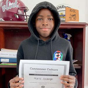 grade 8 student smiling at camera holding Cannoneer Culture certificate for Being Productive