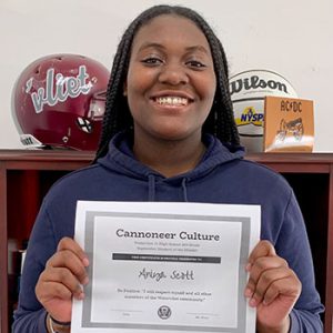 grade 8 student smiling at camera holding Cannoneer Culture certificate for Being Positive