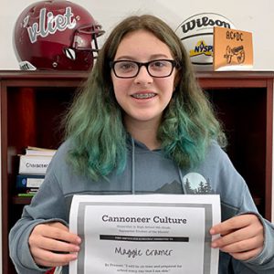 grade 8 student smiling at camera holding Cannoneer Culture certificate for Being Present 