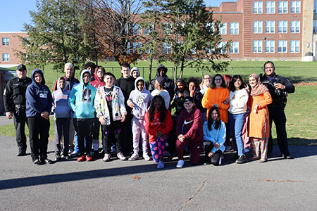 An eighth grade health class stands as a group with the Albany County Stop DWI program representatives, health teacher and school resource officer.